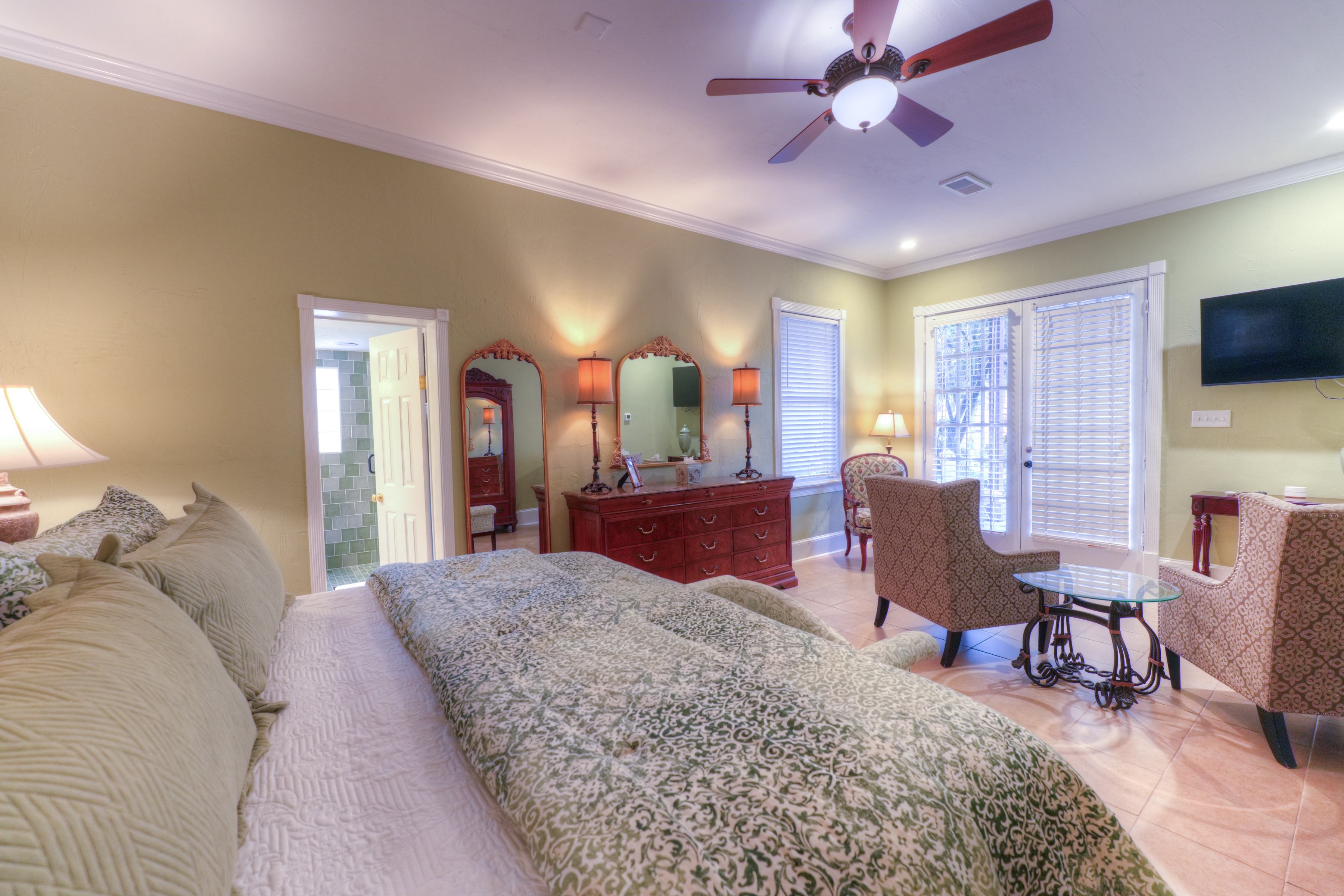 Spacious guestroom featuring two matching antique mirrors with dressing table. Large french-door on entrance.