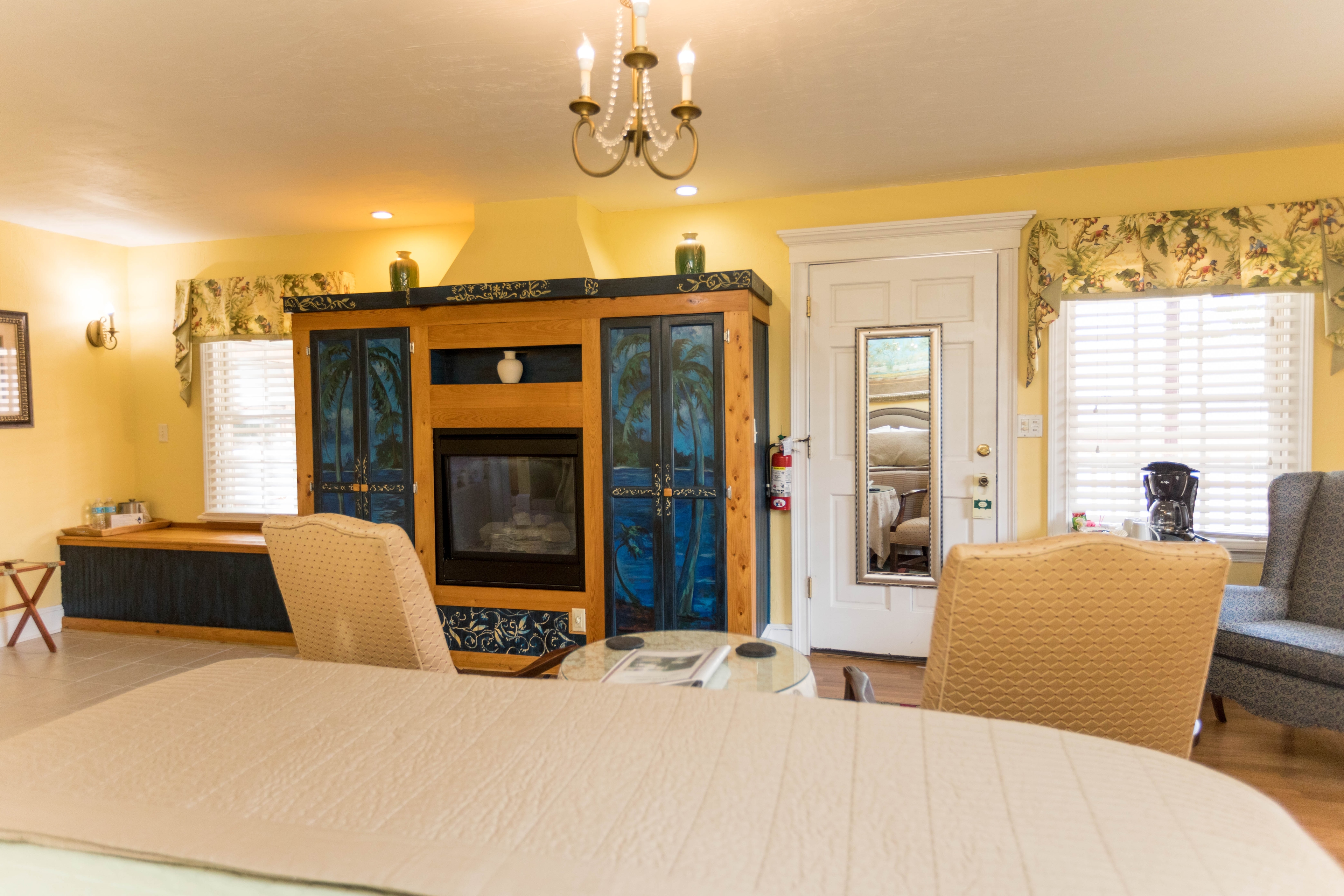 On the wall opposite the bed is a large entertainment center that has been professionally handpainted with a tropical beach mural.  The entertainment center houses an electric fireplace.