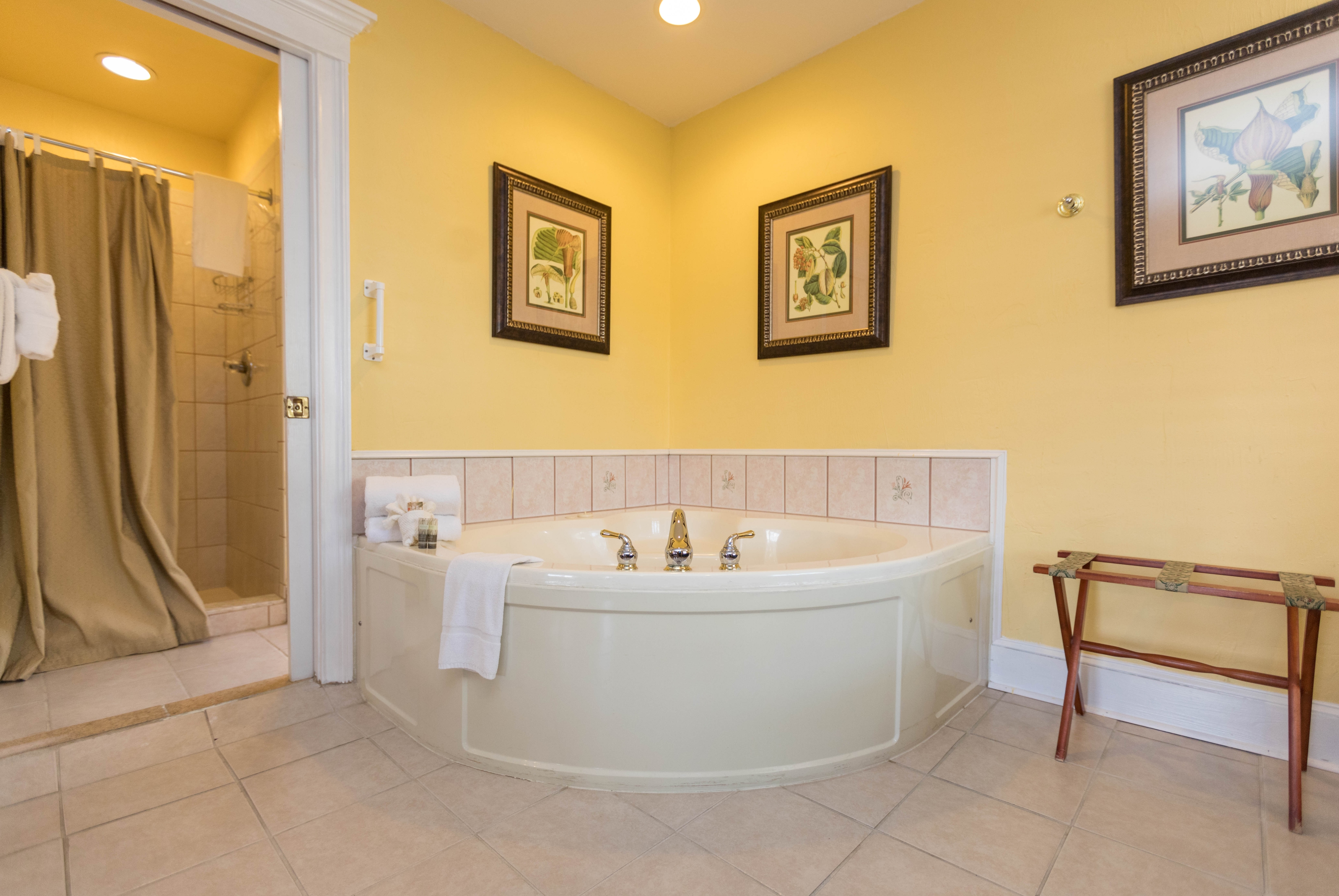 A whirlpool tub graces the corner of the bedroom.  To the left of the tub is the doorway into the private bath with shower.