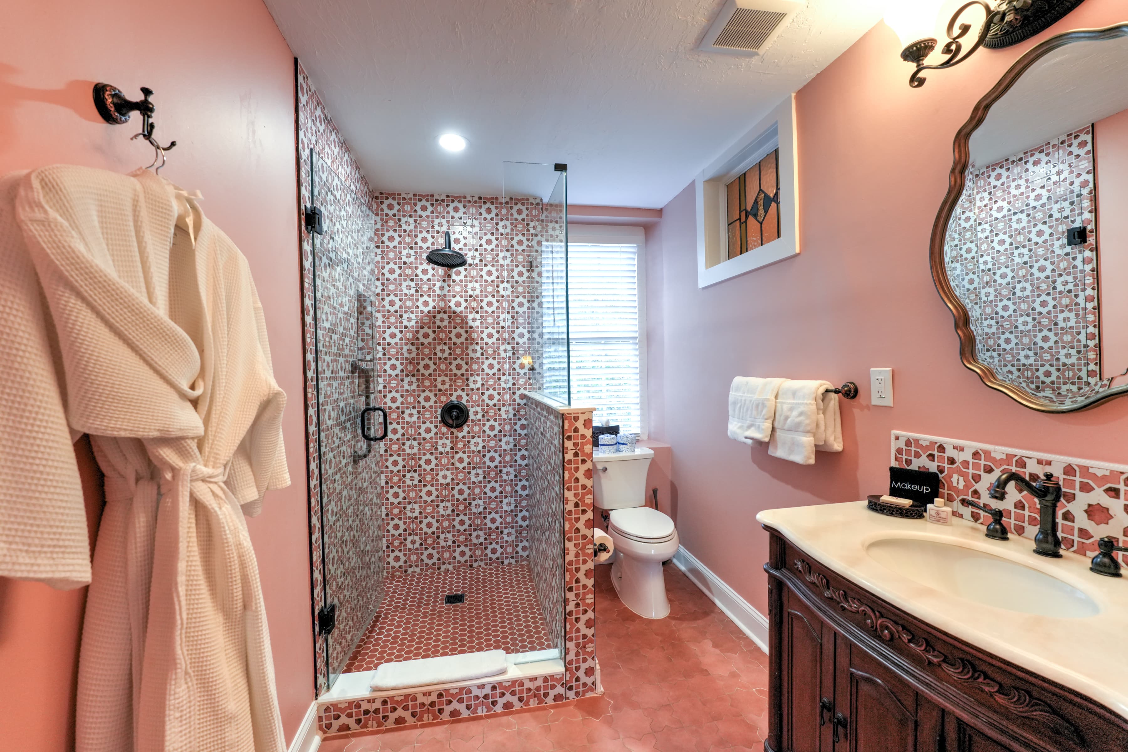 Bright bathroom space which is decorated with Spanish style tiles in Terracotta color, Luxurious Bathrobes and Premium toiletry