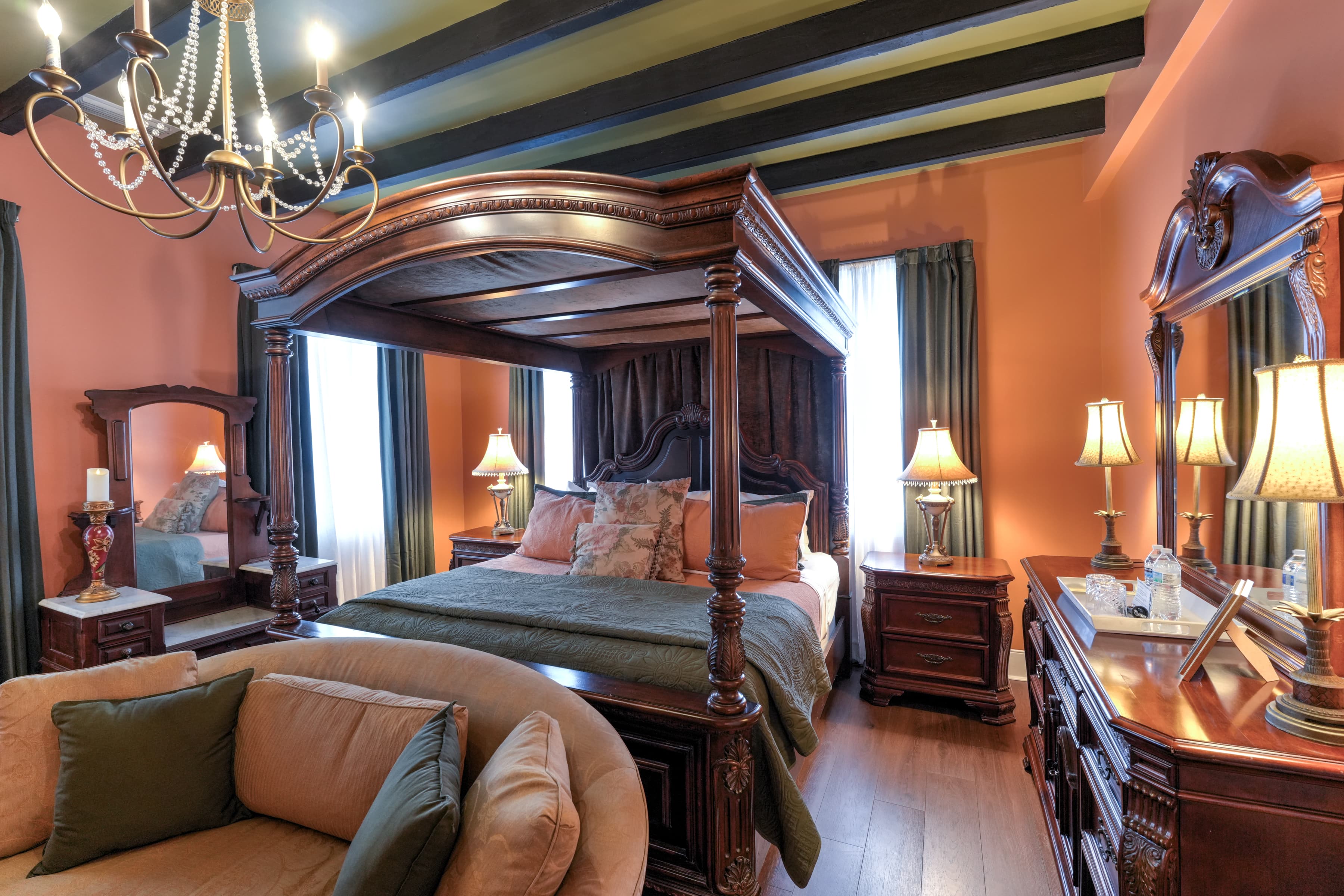 Romantic, luxurious guestroom with canopy four-poster king bed, beam ceiling, and