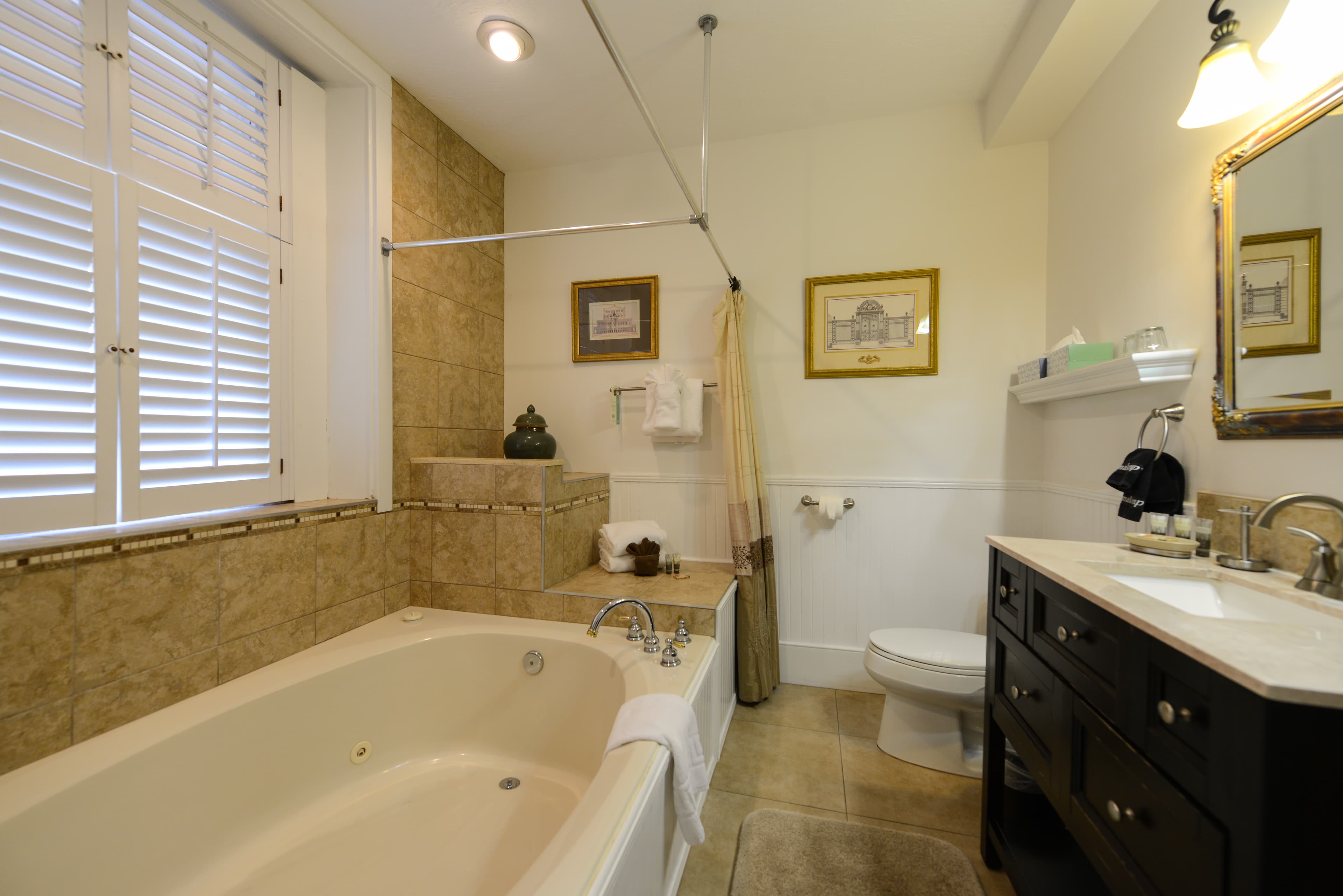 Large private bath with two-person whirlpool garden tub, sink with vanity and toilet