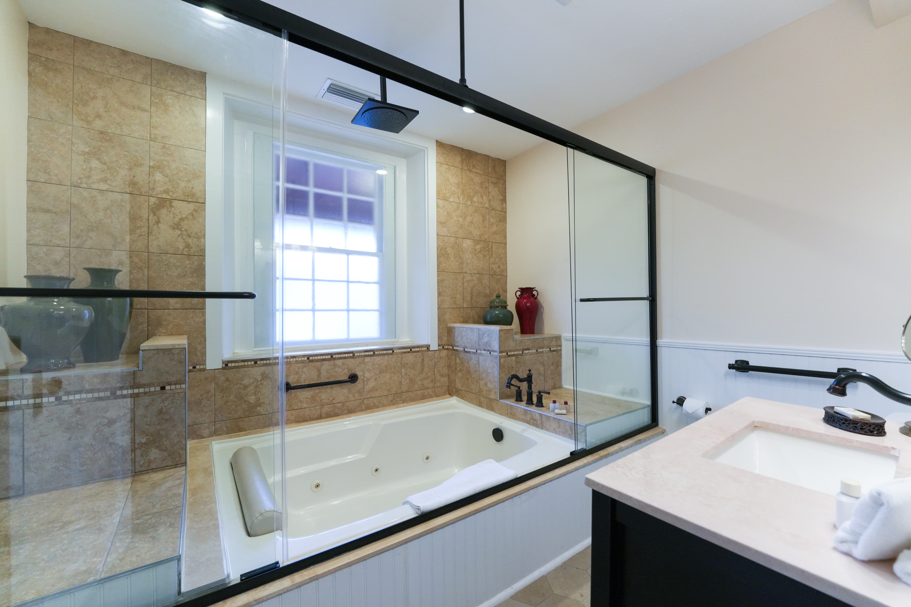 Spacious bathroom with two-person whirlpool garden tub and sink with vanity