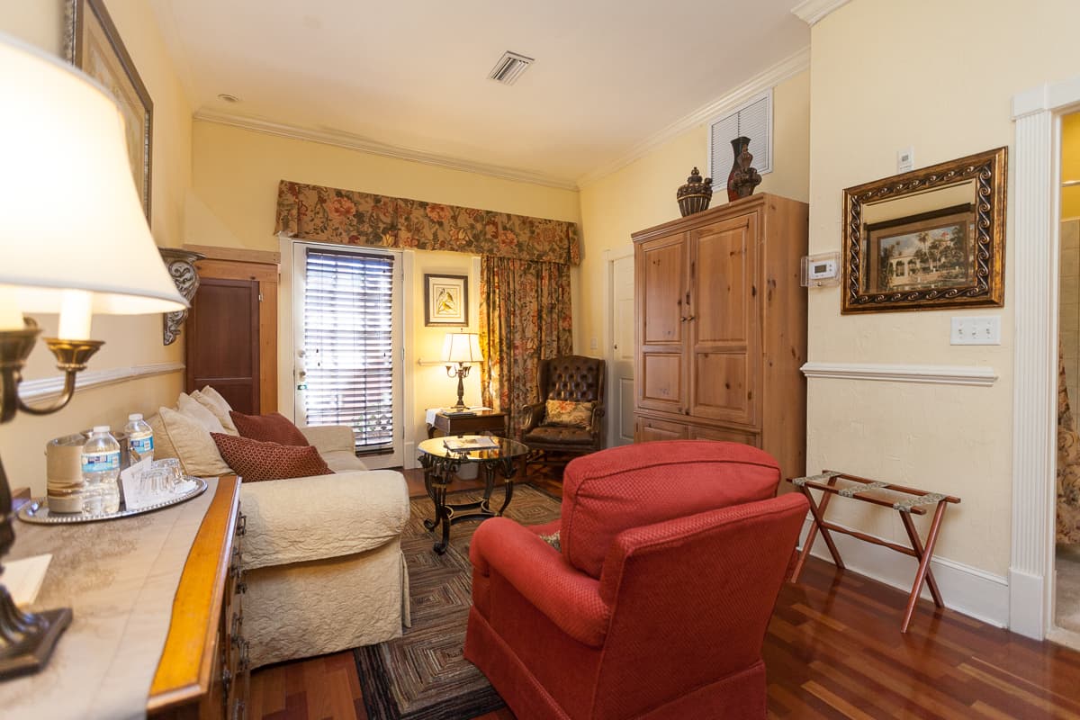 Inviting sitting area with entertainment armoire, sofa, coffee table, and upholstered armchairs.