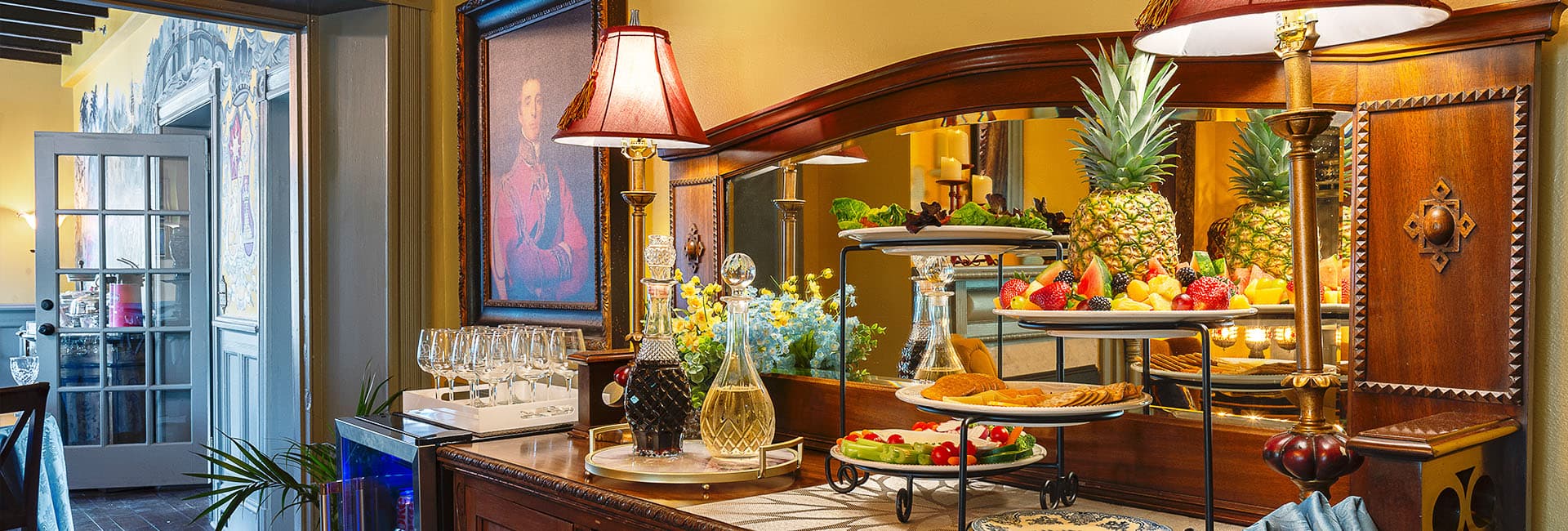A beautifully arranged buffet table features fresh fruits, cookies, and decorative items in an elegantly styled room.