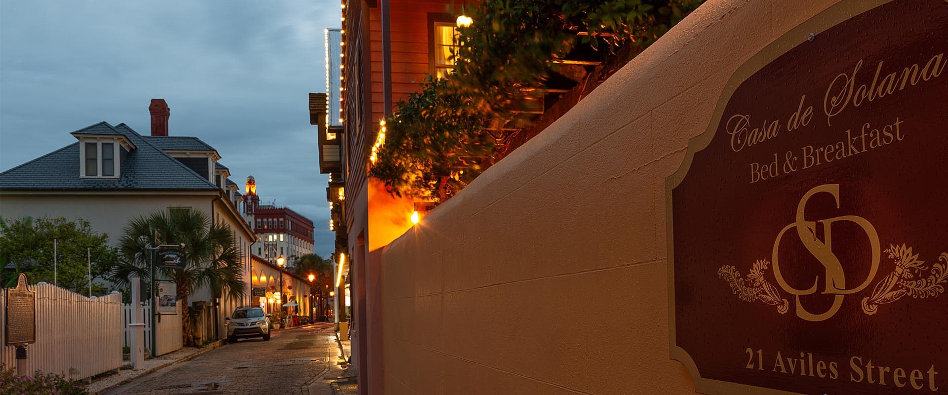 A quaint street scene featuring the Casa de Solana Bed & Breakfast sign along a charming, dimly lit alley.
