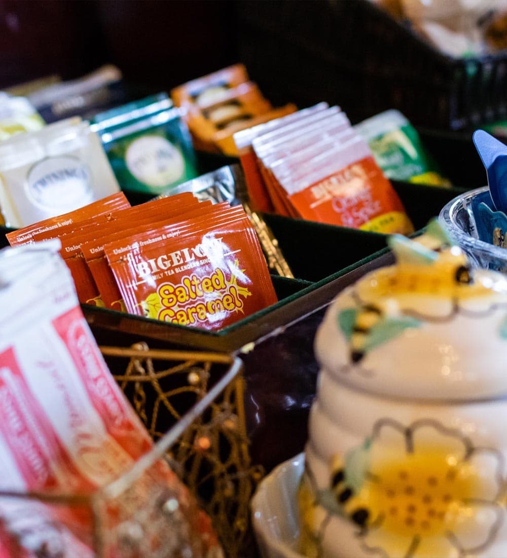 A variety of tea and flavored sachets arranged in a basket.